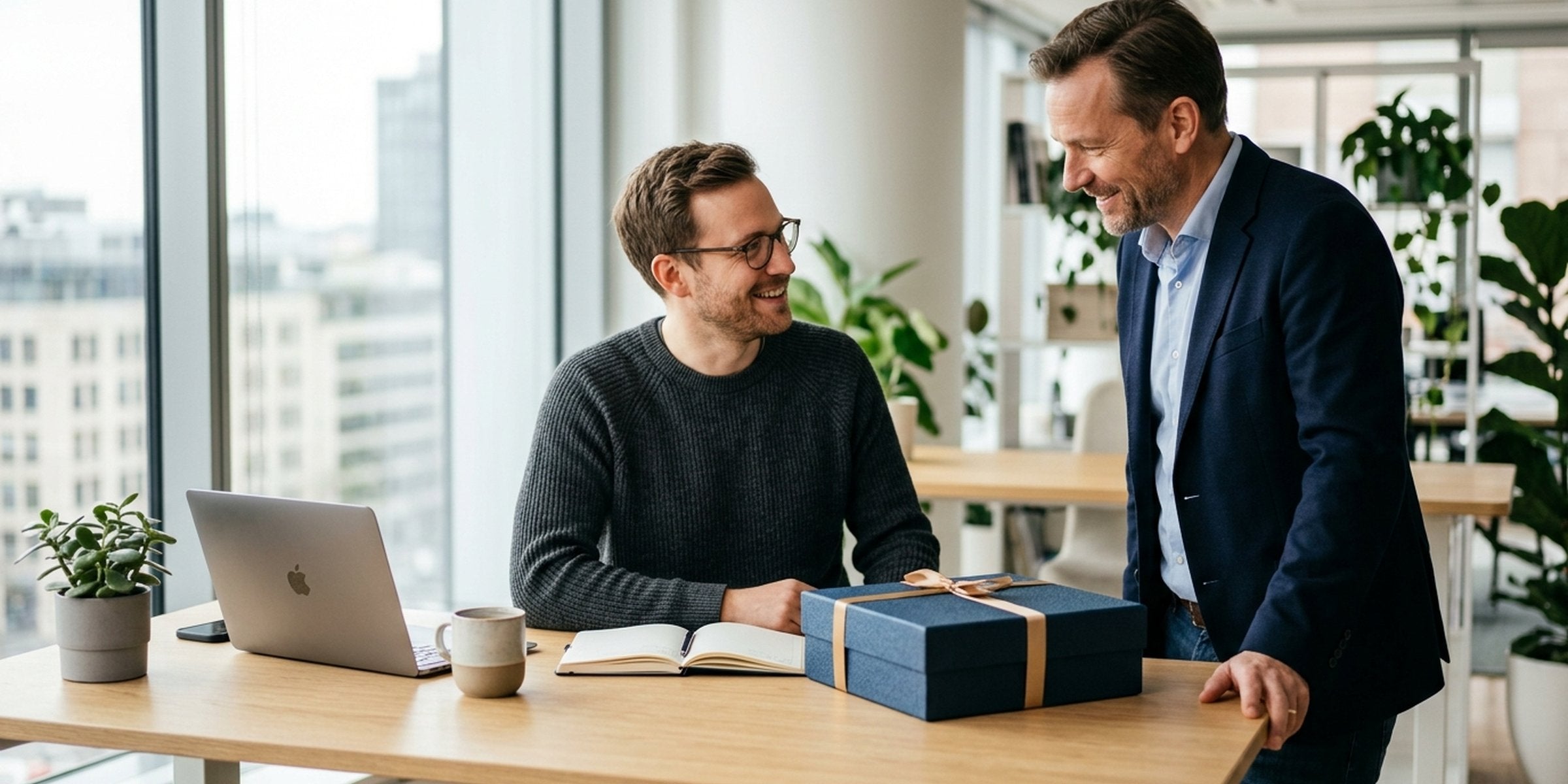 Mitarbeiter überreicht dem Chef ein wertiges, dezentes Geschenk im Büro